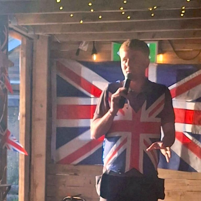 Nathan from the Back of Beyond team stands in front of a Union Flag at Monty's Bar