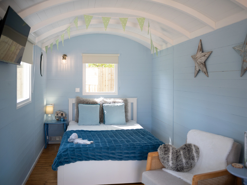 The interior of Sorrel shepherd hut with double bed and TV