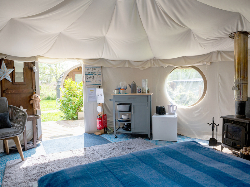 Looking from the bed of the yurt out towards the glamping village